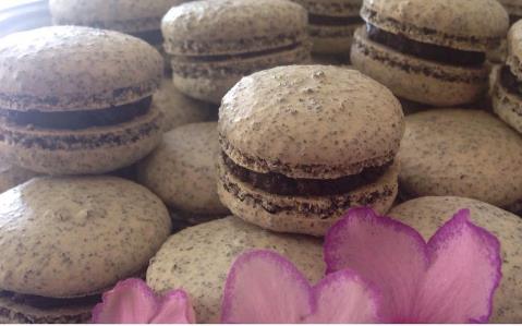 Speckled cocoa macarons with dark chocolate filling and purple petals