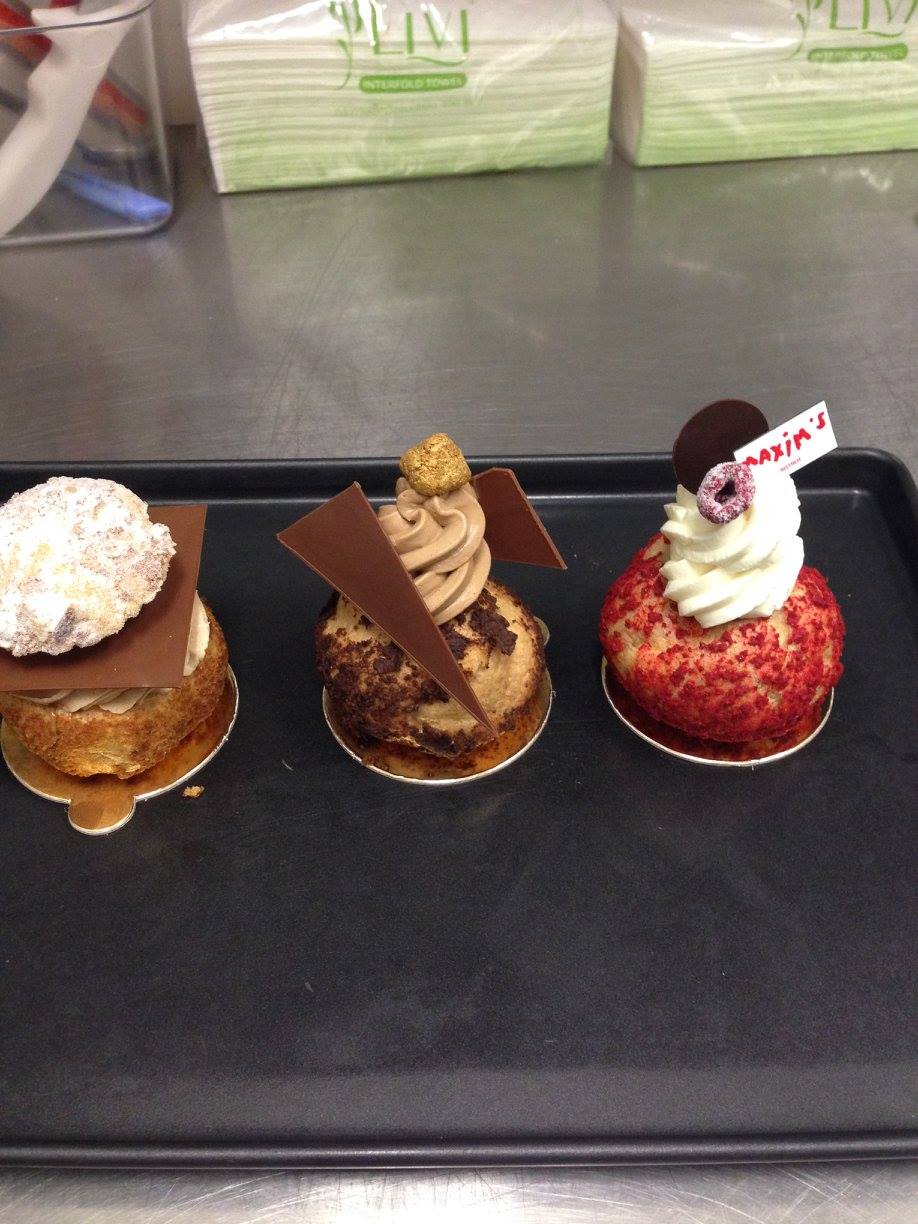 Three decorated choux pastries with vanilla, chocolate and raspberry finishes