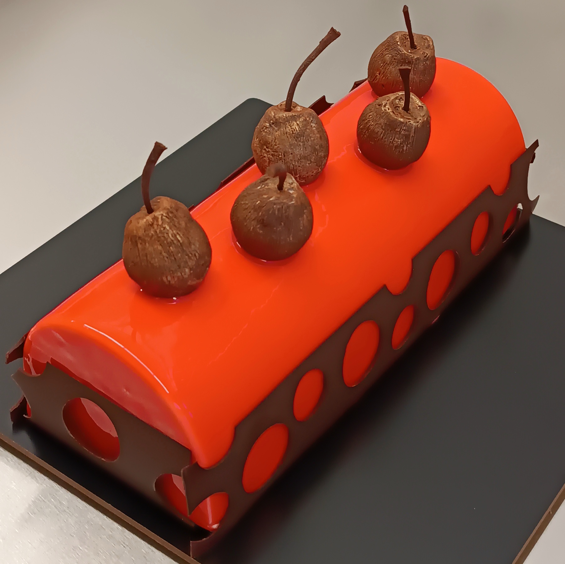 Vivid red rectangular cake with chocolate accents and a clean glazed finish