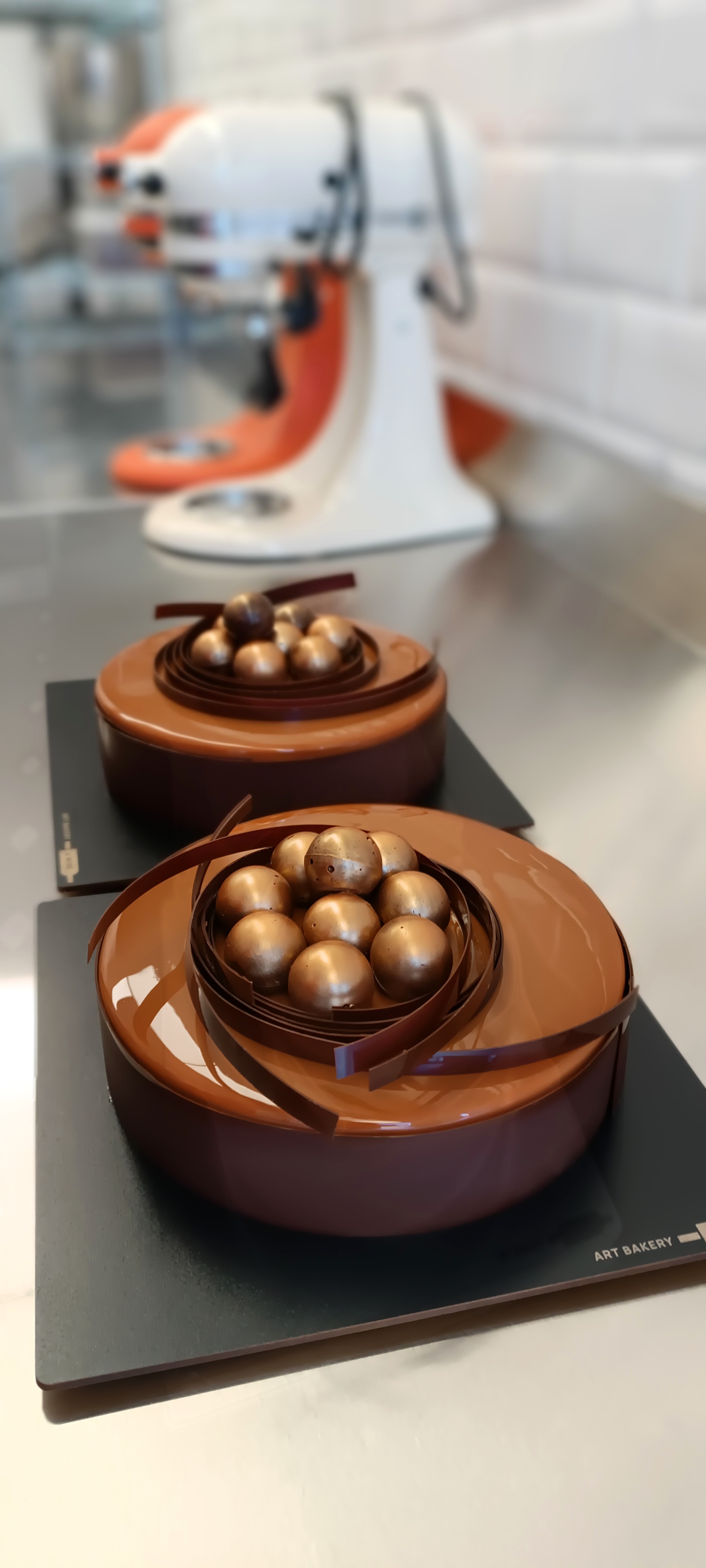 Polished chocolate cake with sculptural decoration and a deep cocoa finish