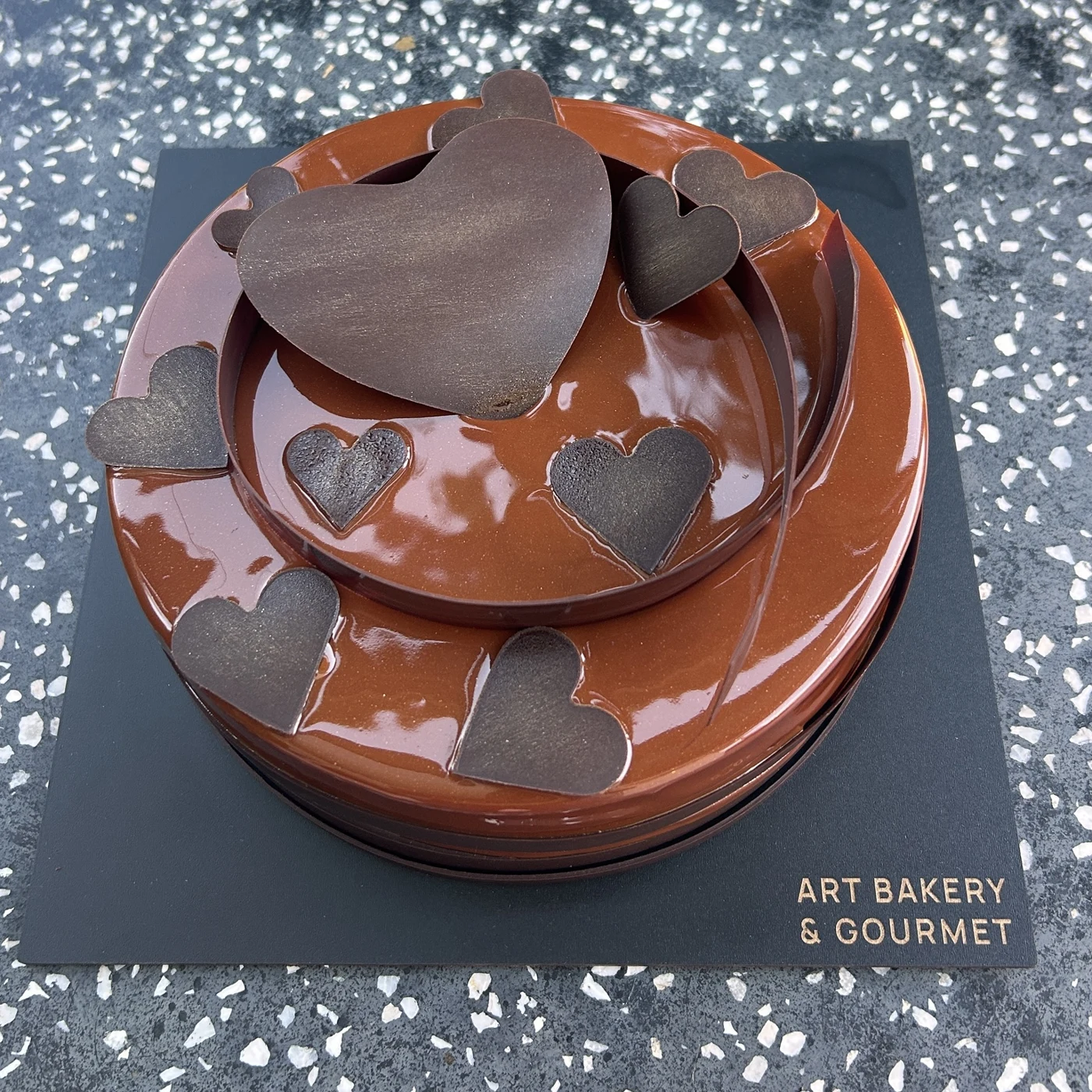 Chocolate-glazed cake with dark chocolate hearts at Art Bakery & Gourmet