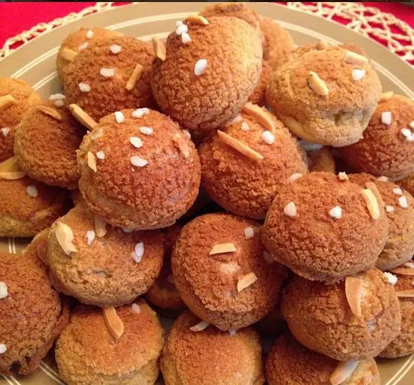 Tray of small round choux pastries with craquelin and nut decoration