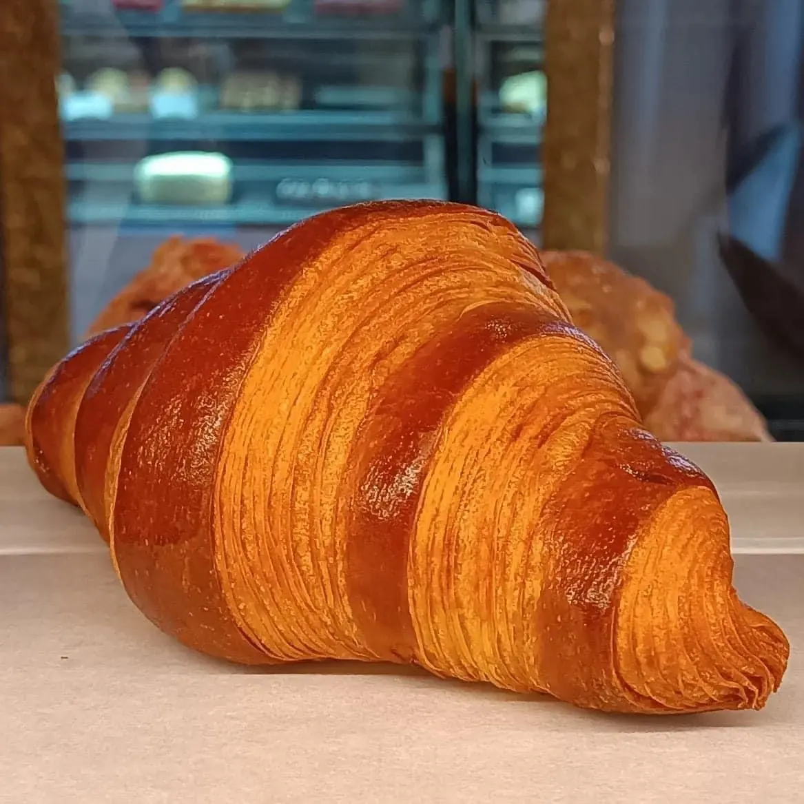 Golden butter croissant with distinct curved laminated layers