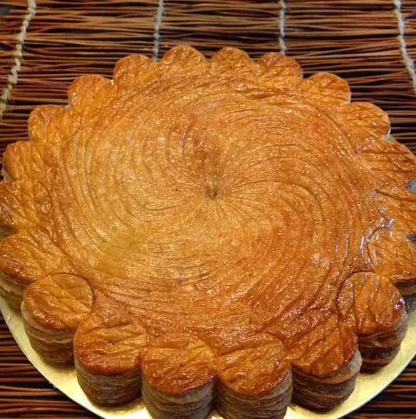 Round French puff-pastry galette with decorative scoring and an even golden bake