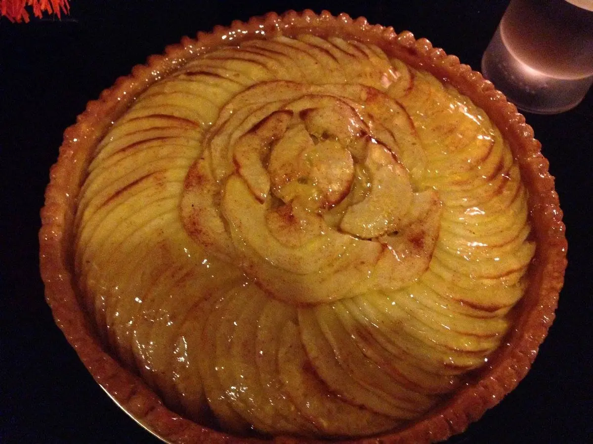 Apple tart with thin overlapping glazed apple slices on crisp pastry