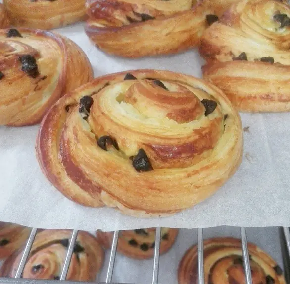 French pain aux raisins pastries with visible laminated spirals, vanilla pastry cream and raisins
