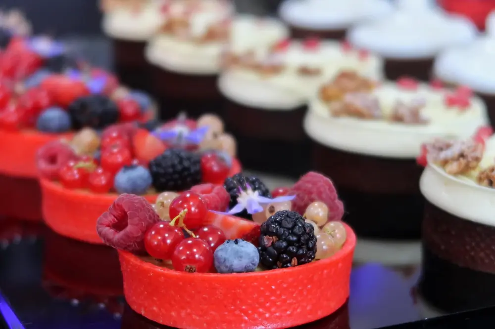 Assorted berry tartlets in neat red and chocolate pastry shells